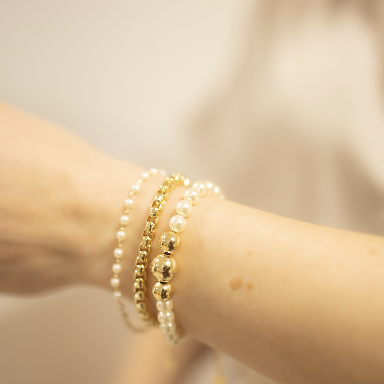 12.2196.15.O - Pulseira de pérolas com três bolas centrais em metal lisas