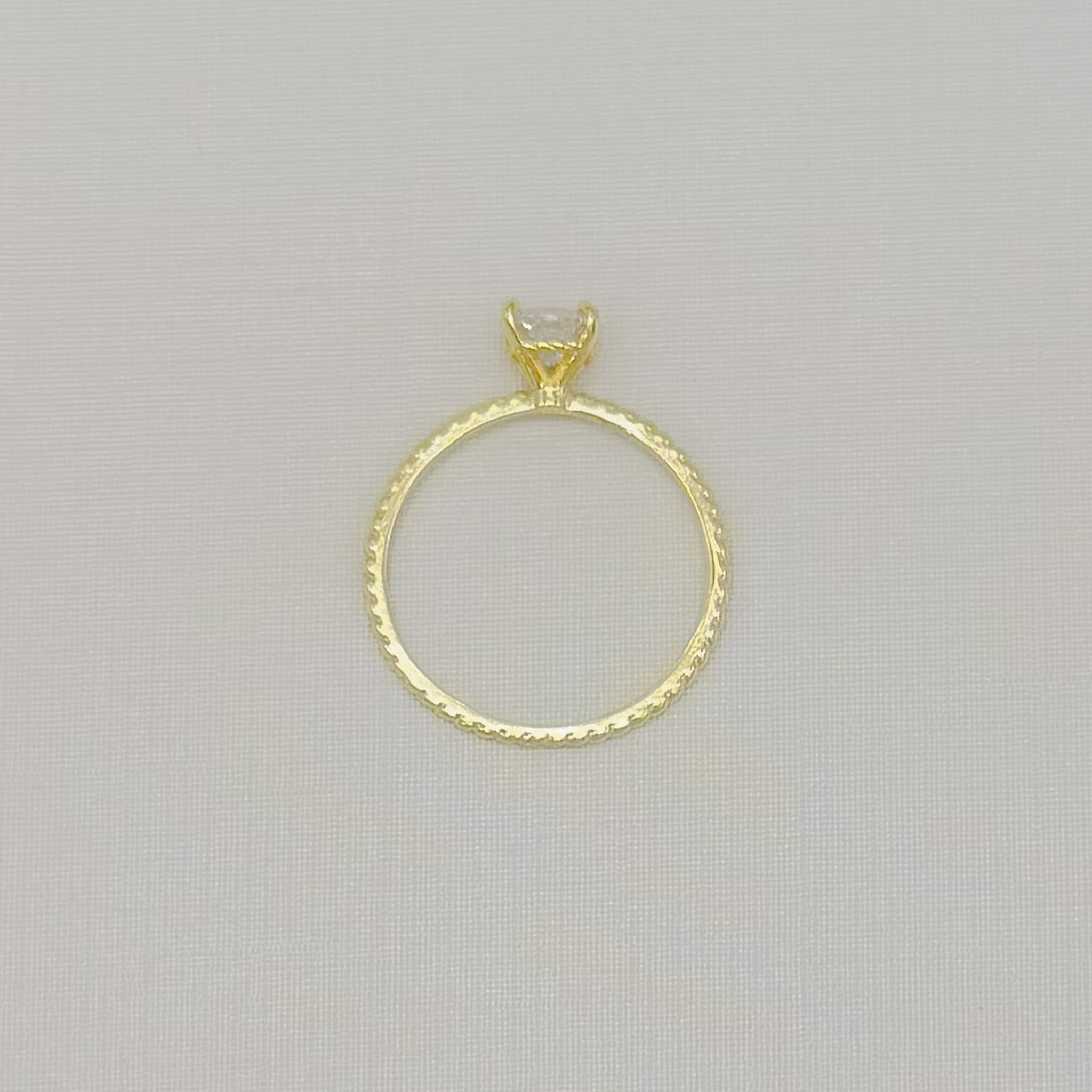 03.2669.1.O - (21) Anel solitário alto de cravação quatro garras em aro fino de efeito torcido