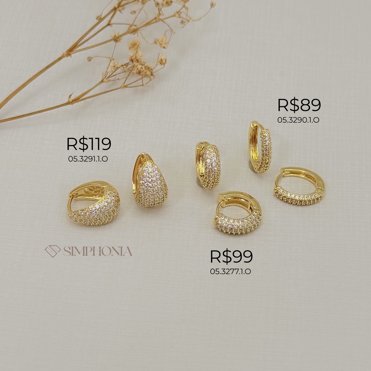 05.3291.1.O - Argola em formato de garra larga com frente cravejada e parte de atrás com flor vazada, tamanho 13x9mm. Argola banhada em ouro.