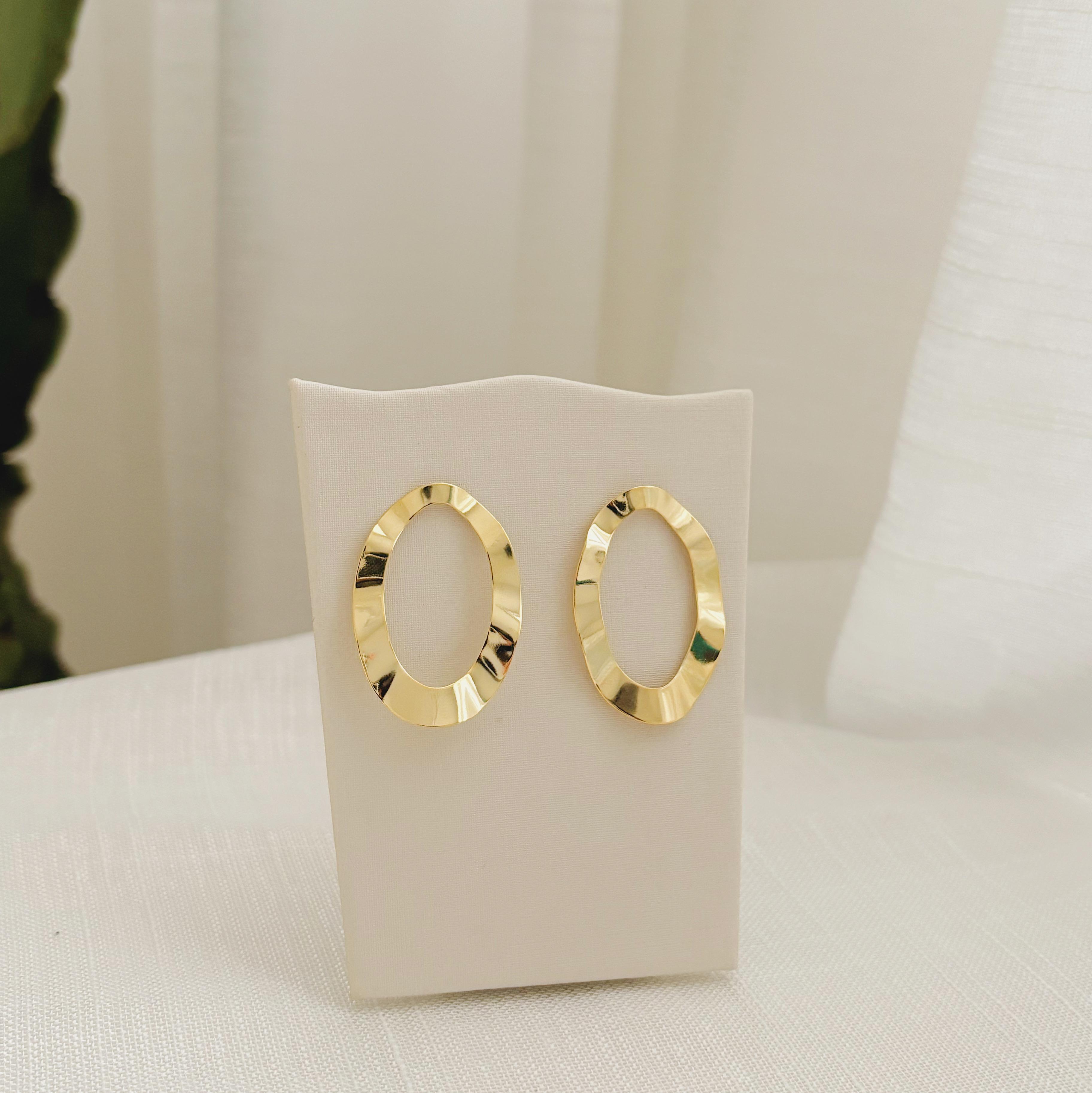 BRINCO ORGÂNICO OVAL VAZADO . BANHADO A OURO 18K.
