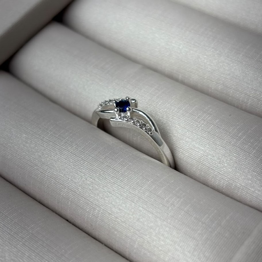Anel Com Duas Linhas Com Zircônias Nas Laterais e Uma Linha Lisa Com Zircônia Azul no Centro Folheado a Prata