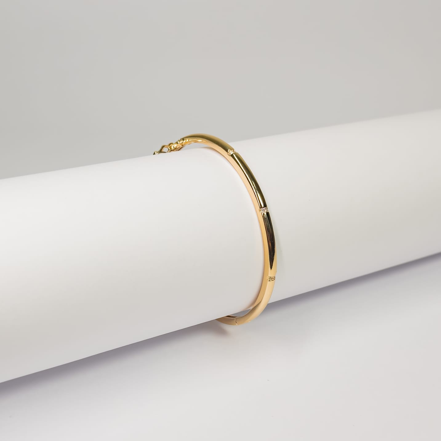 Bracelete liso com detalhes  cravejado em zircônias banhado a ouro 18k
